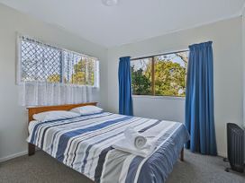 A bedroom with a bed and windows at Joes Place - Cooks Beach Holiday Home Cooks Beach