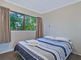 A bedroom with a bed and window at Joes Place - Cooks Beach Holiday Home, Cooks Beach