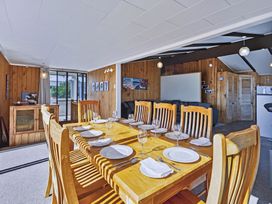 A dining room with a large table set for dinner at Joes Place - Cooks Beach Holiday Home Cooks Beach