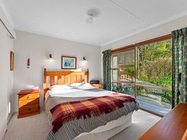 A bedroom with a bed and bedside table at Ruatotara - Pukawa Holiday Home, Pukawa Bay