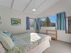 A bedroom with a bed and window at Ruatotara - Pukawa Holiday Home Pukawa Bay