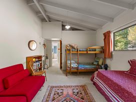 A bedroom with a bunk bed and a double bed at Ruatotara - Pukawa Holiday Home Pukawa Bay