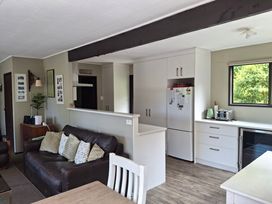 A living room with a sofa and dining table at Lake House and Studio - Lake Rotoiti