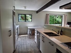A kitchen with a sink and fridge at Lake House and Studio - Lake Rotoiti