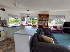 A living room with kitchen and dining table at Silver Sands - Cooks Beach Holiday Home Cooks Beach