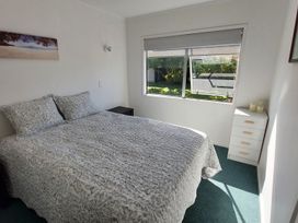 A bedroom with a bed and a window at Silver Sands - Cooks Beach Holiday Home Cooks Beach