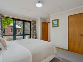 A bedroom with a bed and window at Tranquil Tipperary - Arrowtown Holiday Home, Arrowtown