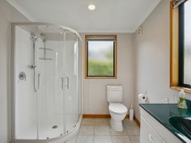 A bathroom with a shower, toilet, and sink at Tranquil Tipperary - Arrowtown Holiday Home in Arrowtown