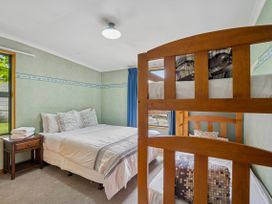 A bedroom with a double bed and a bunk bed at Tranquil Tipperary - Arrowtown Holiday Home Arrowtown