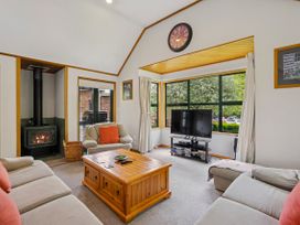A living room with a fireplace and television at Tranquil Tipperary - Arrowtown Holiday Home Arrowtown