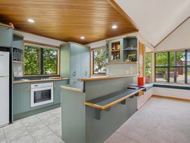 A kitchen with cabinets and appliances at Tranquil Tipperary - Arrowtown Holiday Home Arrowtown