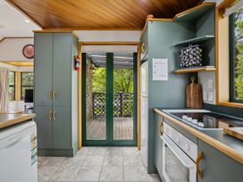 A kitchen with cabinets and appliances at Tranquil Tipperary - Arrowtown Holiday Home in Arrowtown