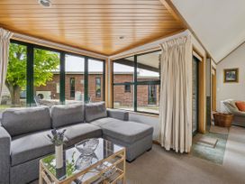 A living room with a sofa and coffee table at Tranquil Tipperary - Arrowtown Holiday Home