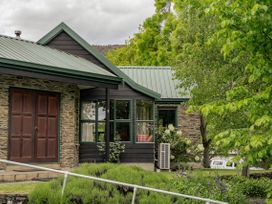 A house with a garden and windows at Tranquil Tipperary - Arrowtown Holiday Home, Arrowtown