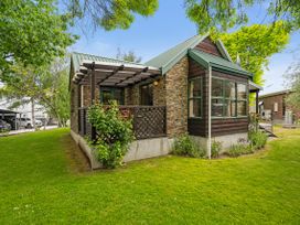 A house with a patio and lawn at Tranquil Tipperary - Arrowtown Holiday Home in Arrowtown