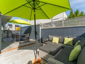 A patio area with outdoor seating and umbrellas at Jacksons - Two Mile Bay Holiday Home in Two Mile Bay