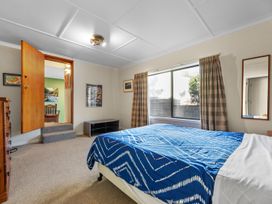 A bedroom with a bed and window at Beach Galore - Waihi Beach Holiday Home Waihi Beach