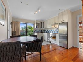 A kitchen with dining table and appliances at Beach Galore - Waihi Beach