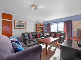 A living room with a sofa and coffee table at Beach Galore - Waihi Beach
