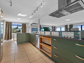 A kitchen with cabinets and a sink at Beach Galore - Waihi Beach