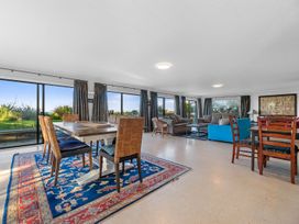 A living room with a dining area and seating at Beach Galore - Waihi Beach