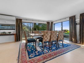 A dining room with a table and chairs at Beach Galore - Waihi Beach