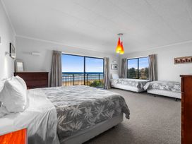 A bedroom with a bed and a single bed at Beach Galore - Waihi Beach