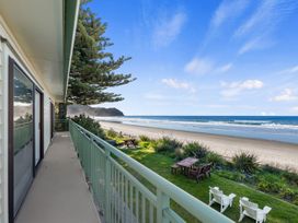 An outdoor view of a beach with trees and seating at Beach Galore - Waihi Beach