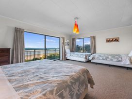A bedroom with beds and a view at Beach Galore - Waihi Beach Holiday Home, Waihi Beach