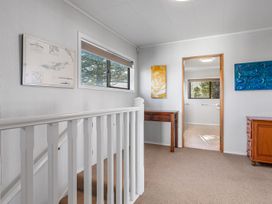 A hallway with a table and window at Beach Galore - Waihi Beach