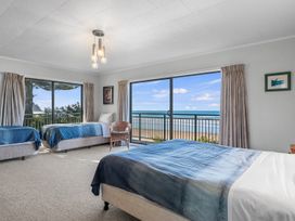 A bedroom with two beds and a view of the beach at Beach Galore - Waihi Beach