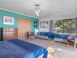 A bedroom with two beds and a dresser at Beach Galore - Waihi Beach Holiday Home