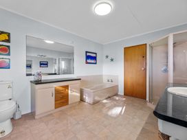 A bathroom with a bathtub and shower at Beach Galore - Waihi Beach Holiday Home