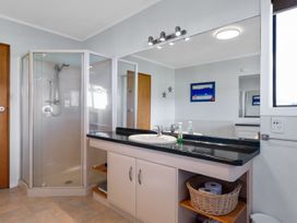 A bathroom with a shower and sink at Beach Galore - Waihi Beach Holiday Home in Waihi Beach