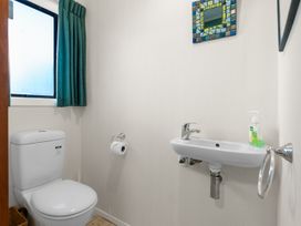 A bathroom with a toilet and sink at Beach Galore - Waihi Beach Holiday Home