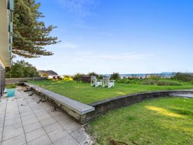 A garden with seating area and view at Beach Galore - Waihi Beach