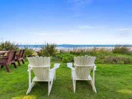 Adirondack chairs facing the ocean at Beach Galore - Waihi Beach