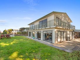An outdoor view of a house with a garden at Beach Galore - Waihi Beach