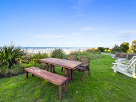 A table and benches near the sea at Beach Galore - Waihi Beach