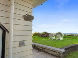 An outdoor area with a shower head and seating at Beach Galore - Waihi Beach