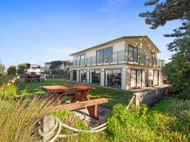 A house with a garden and outdoor furniture at Beach Galore - Waihi Beach