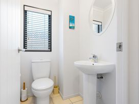 A bathroom with a toilet and sink at The Sandcastle - Papamoa Holiday Apartment