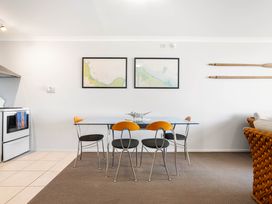 A dining room with a table and chairs at The Sandcastle - Papamoa Holiday Apartment Papamoa