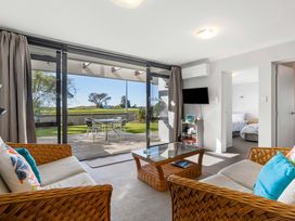 A living room with a table and chairs at The Sandcastle - Papamoa Holiday Apartment in Papamoa
