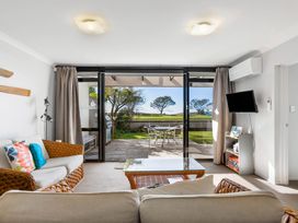 A living room with a sofa and coffee table at The Sandcastle - Papamoa Holiday Apartment, Papamoa