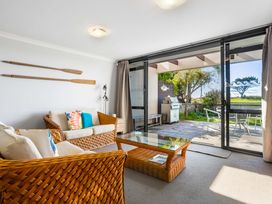 A living room with a sofa and coffee table at The Sandcastle - Papamoa Holiday Apartment, Papamoa