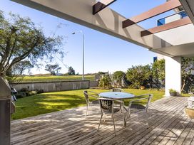 A patio area with a table and chairs at The Sandcastle - Papamoa Holiday Apartment in Papamoa