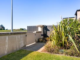 A garden area with a gate and plants at The Sandcastle - Papamoa Holiday Apartment in Papamoa