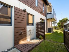 An outdoor shower area next to a house at The Sandcastle - Papamoa Holiday Apartment Papamoa