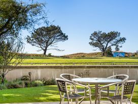 A table and chairs in an outdoor area at The Sandcastle - Papamoa Holiday Apartment in Papamoa